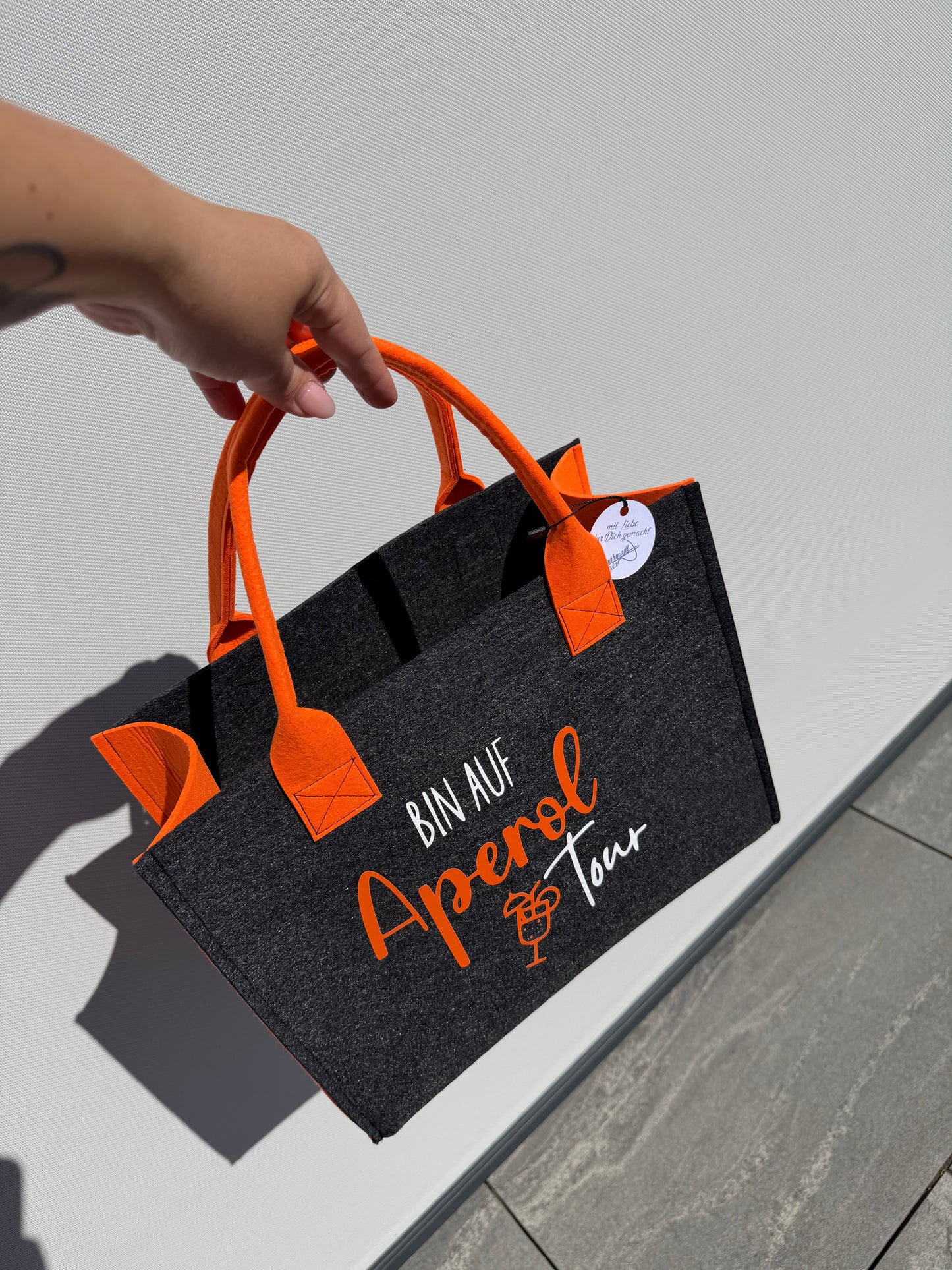 Handgefertigte anthrazitfarbene Filztasche mit orangenen Tragegriffen und dem Spruch „Bin auf Aperol Tour“ – stylische Shopper-Tasche für Sommer, Freizeit und Urlaub.