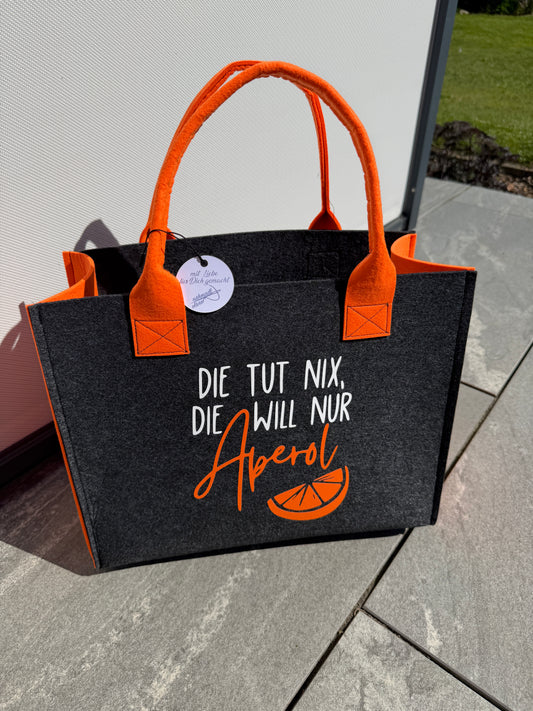 Handgefertigte anthrazitfarbene Filztasche mit orangenen Tragegriffen und dem Spruch „Die tut nix, die will nur Aperol.“ – die perfekte Tasche für Camping und Sommer.