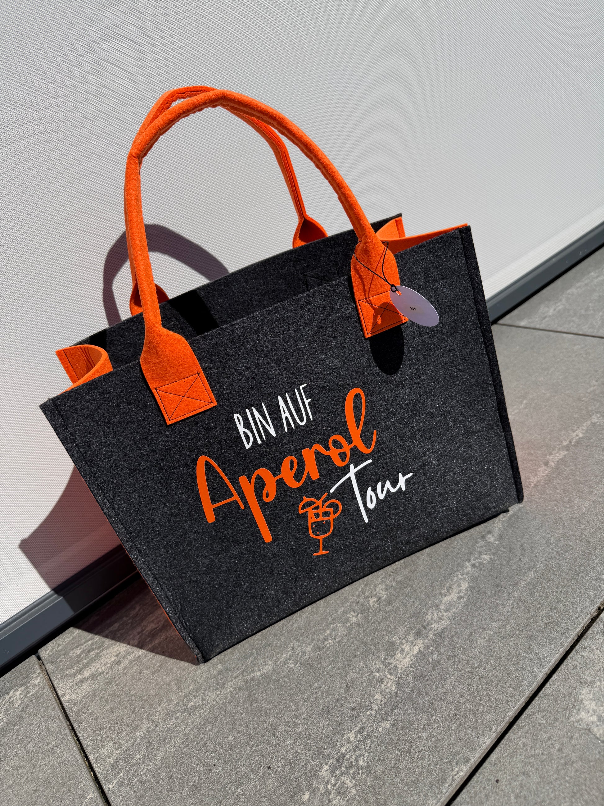 Handgefertigte anthrazitfarbene Filztasche mit orangenen Tragegriffen und dem Spruch „Bin auf Aperol Tour“ – stylische Shopper-Tasche für Sommer, Freizeit und Urlaub.