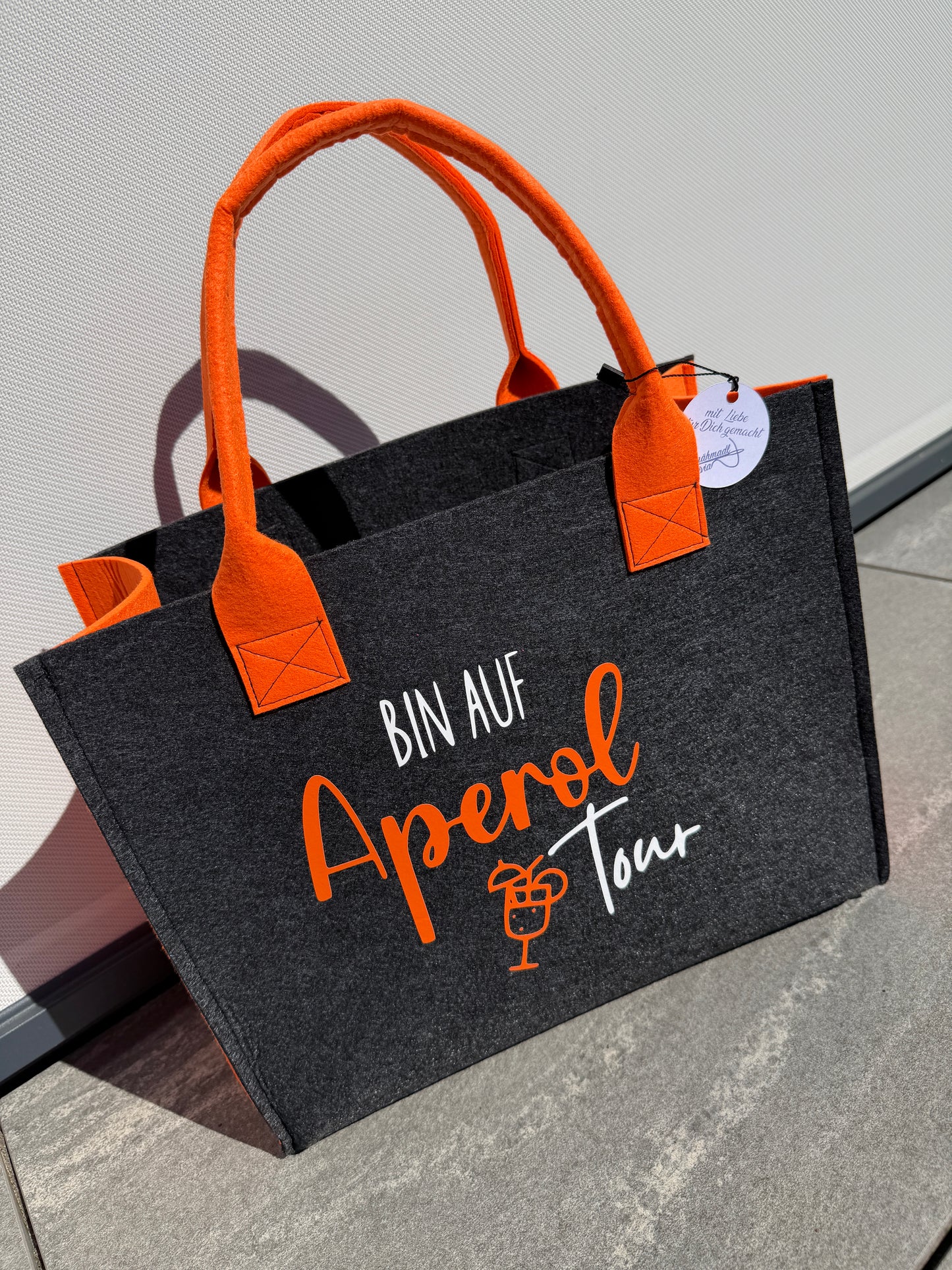 Handgefertigte anthrazitfarbene Filztasche mit orangenen Tragegriffen und dem Spruch „Bin auf Aperol Tour“ – stylische Shopper-Tasche für Sommer, Freizeit und Urlaub.